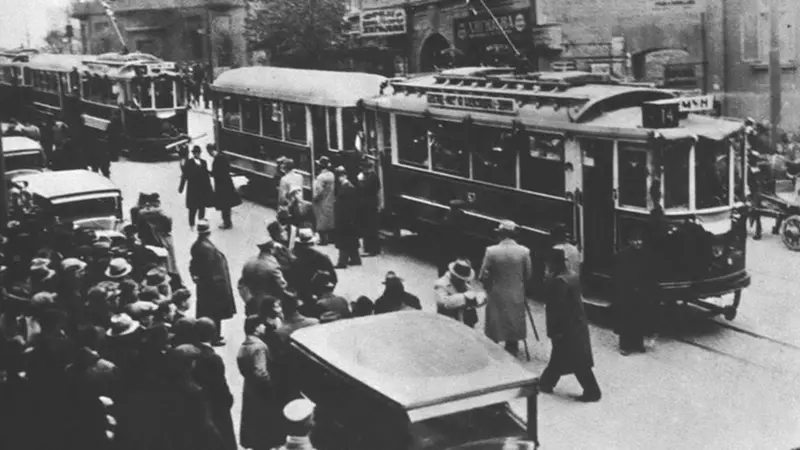 Kako je Beograd prešao put od 'konjskog' do modernih tramvaja 11 Tramvaj na ulicama Beograda dok ljudi šetaju pored njega, crno-bela fotografija
