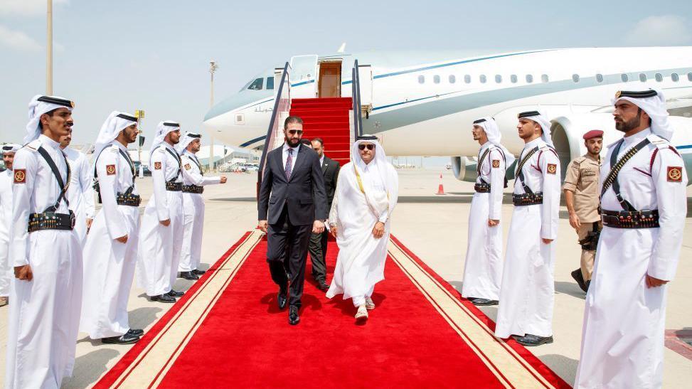 Kako je Tramp postigao dogovor za Gazu, koji je uporno izmicao Bajdenu 3 Sirijski predsednik Ahmed al-Šar hoda crvenim tepihom pošto je sišao sa aviona u Dohi