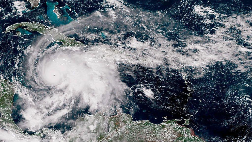 Kako nastaju uragani, postanu razorni i nestanu 1 Satelitski snimak prikazuje veliki, dobro definisan uragan iznad Karipskog mora. Oluja ima jasno oko i spiralne oblačne trake koje se protežu preko Haitija, Dominikanske Republike i istočne Kube, sa okolnim oblačnim pokrivačem koji se proteže prema Bahamima i severnim delovima Južne Amerike