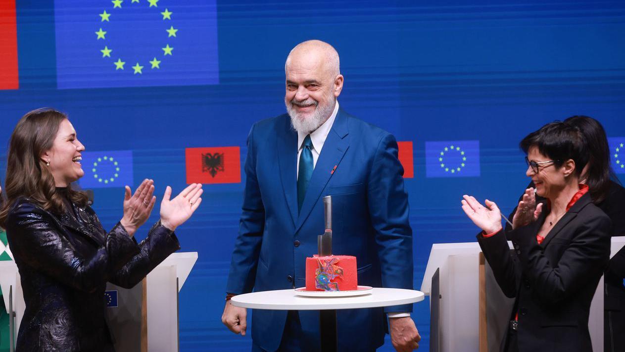 Mara Bjeri, danska ministarka za evropske poslove (levo) albanski premijer Edi Rama (u sredini) i Marta Kos, evropska komesarka za proširenje (desno) oko stola na kojem je crvena torta 