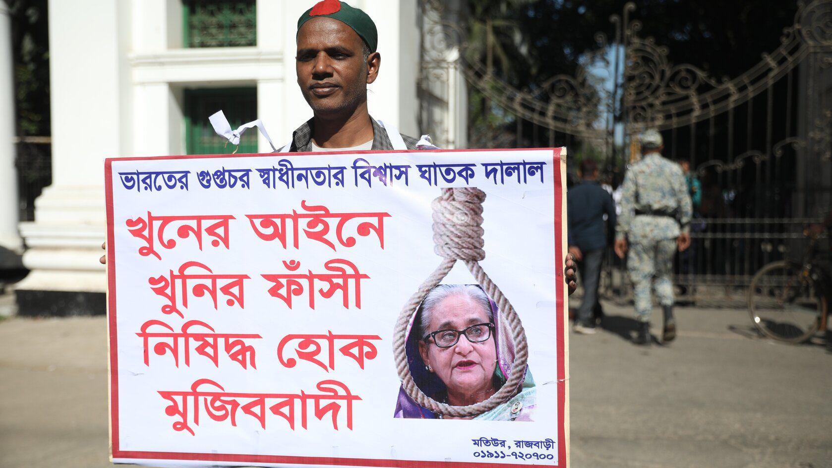 Bivša premijerka Bangladeša osuđena na smrt 1 Muškarac drži u ruci transparent na kojem je slika bivše premijerke Šeike Hasani