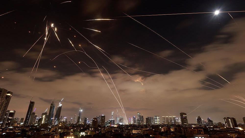 Noćno nebo osvetljeno vazdušnim napadima iznad Tel Aviva 16. juna 2025. padajućim 