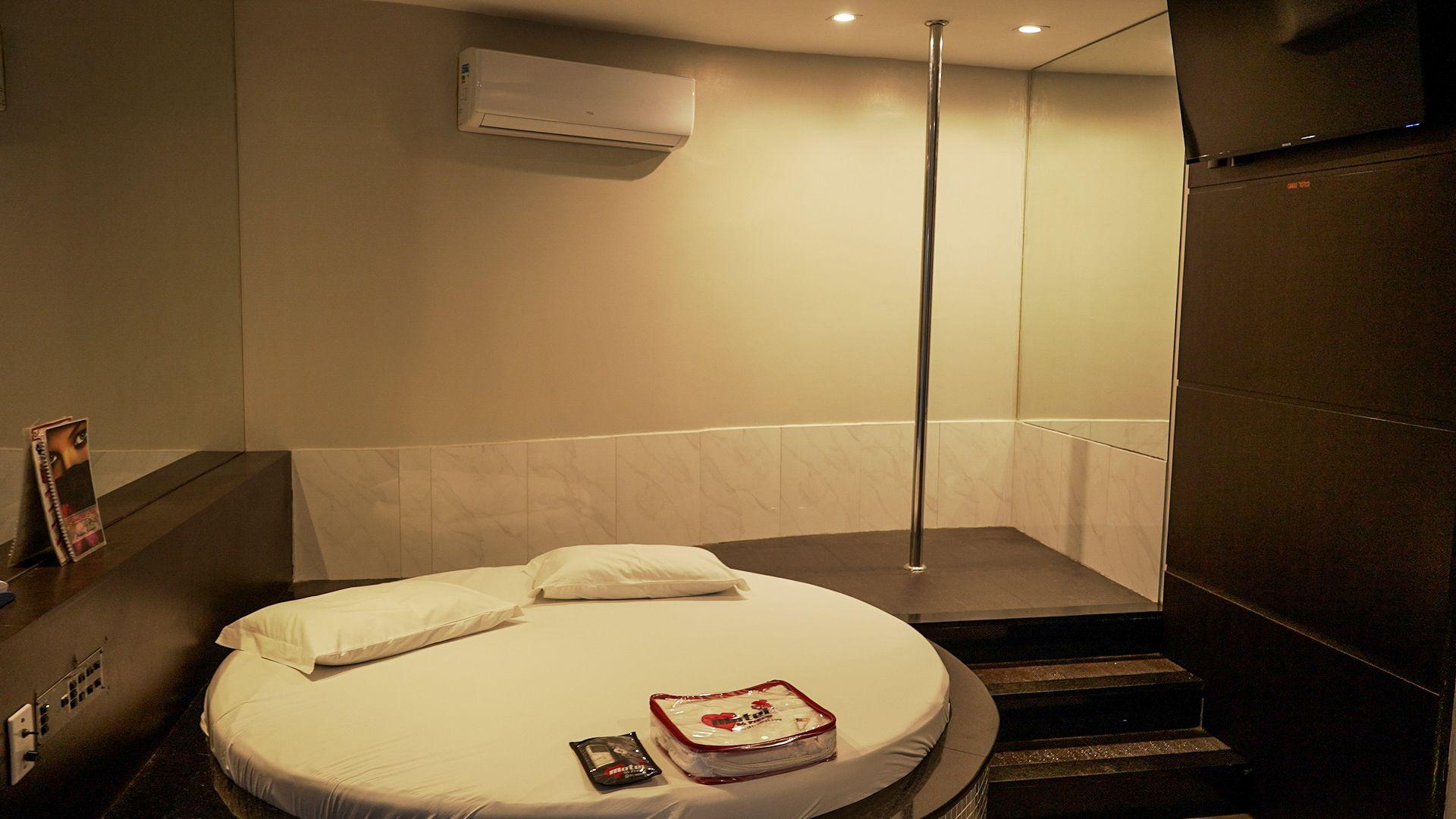 Okrugli krevet, dva jastuka i lampa u motelskoj sobi