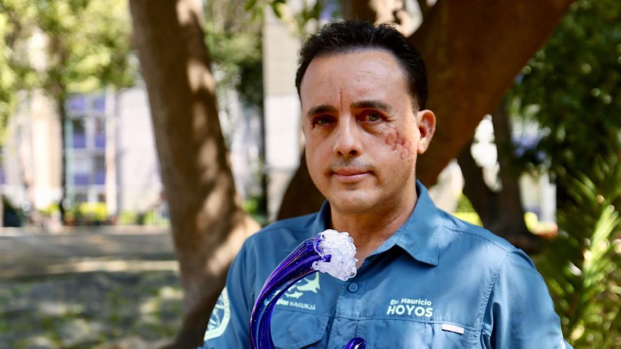 Maurisio Hojos gleda u kameru dok drži nagradu u obliku talasa