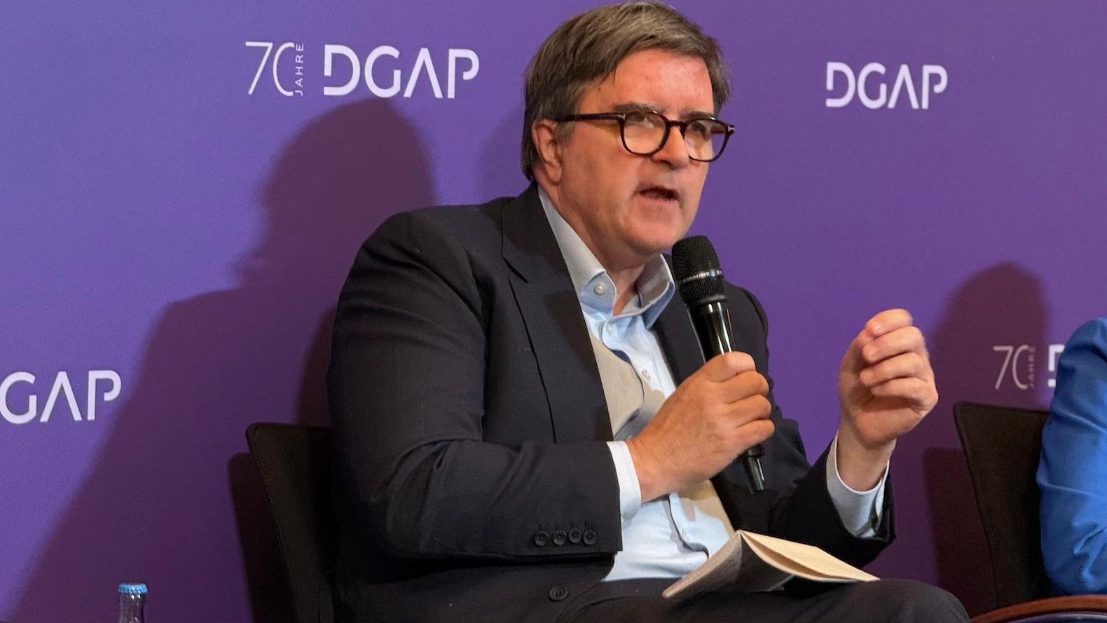 Džejms O'Brajen na panel diskusiji, čovek sa naočarima govori držeći u rukama mikrofon