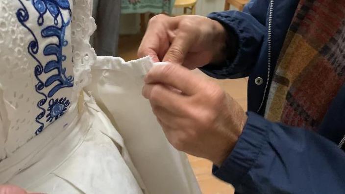 Žena ušiva haljinu drugoj ženi