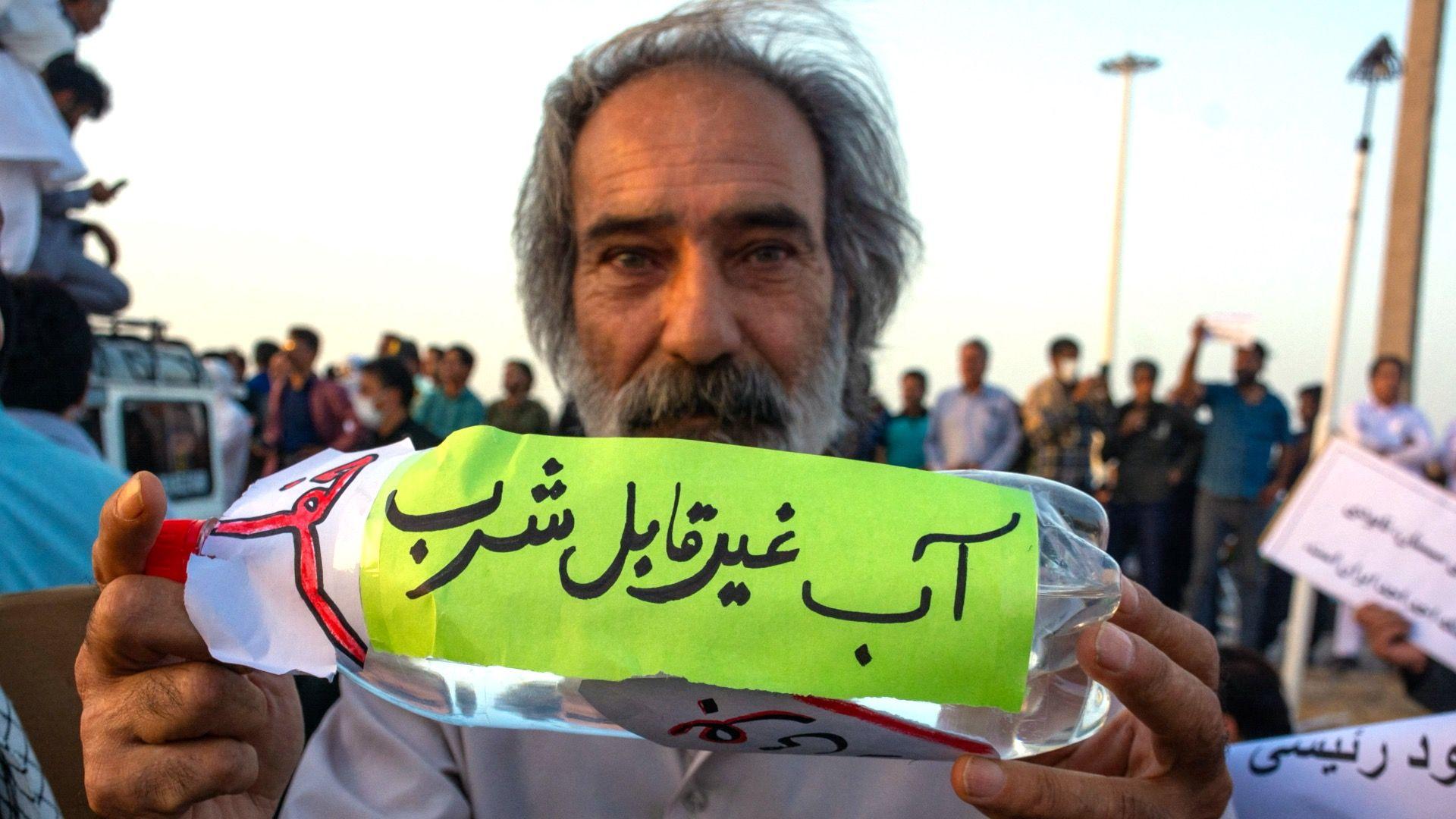 'Nulti dan' u Teheranu: Milioni ljudi u iranskoj prestonici ostaju bez vode 1 Upozorenje: Voda nije za piće natpis je na flaši koju drži čovek koji protestuje u Iranu, suša u iranu, iran ostaje bez pijaće vode