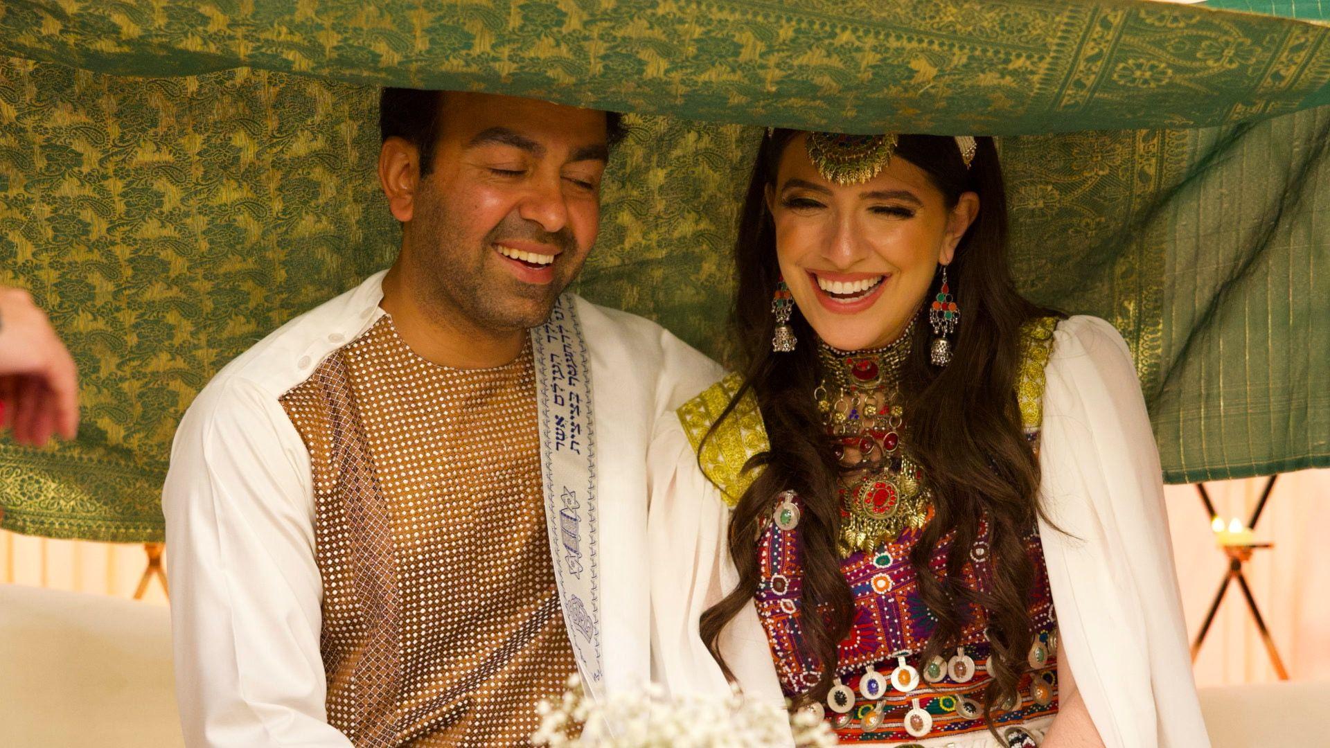 Sami i Safi sede ispod zelene tkanine na njihovom venčanju 