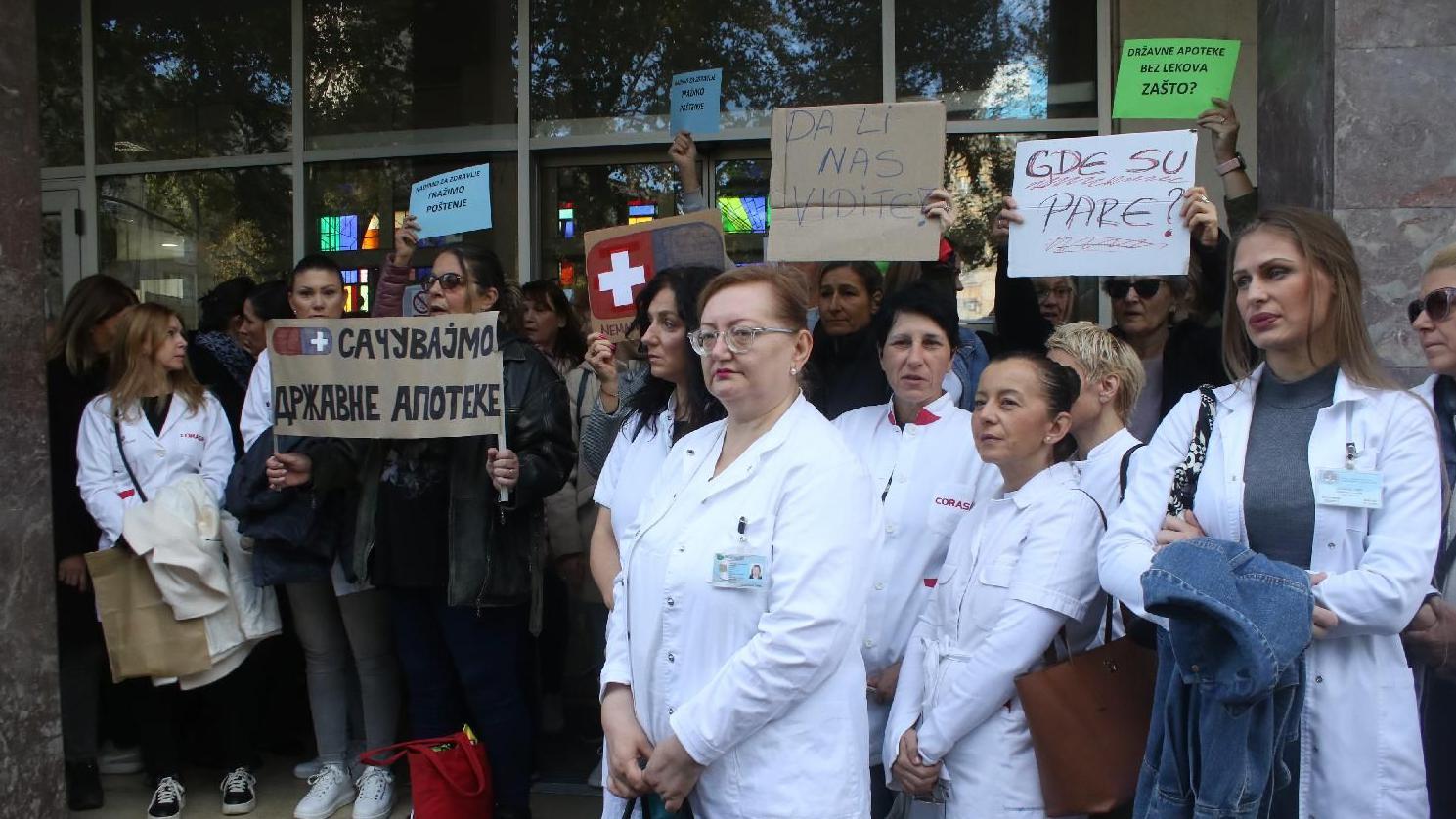 Ljudi stoje i drže transparente na protestu