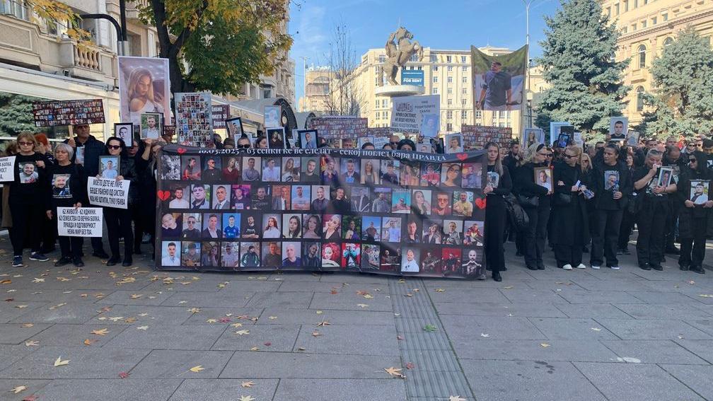 Grupa ljudi drži veliki transparent sa slikama žrtava tragedije u Skoplju
