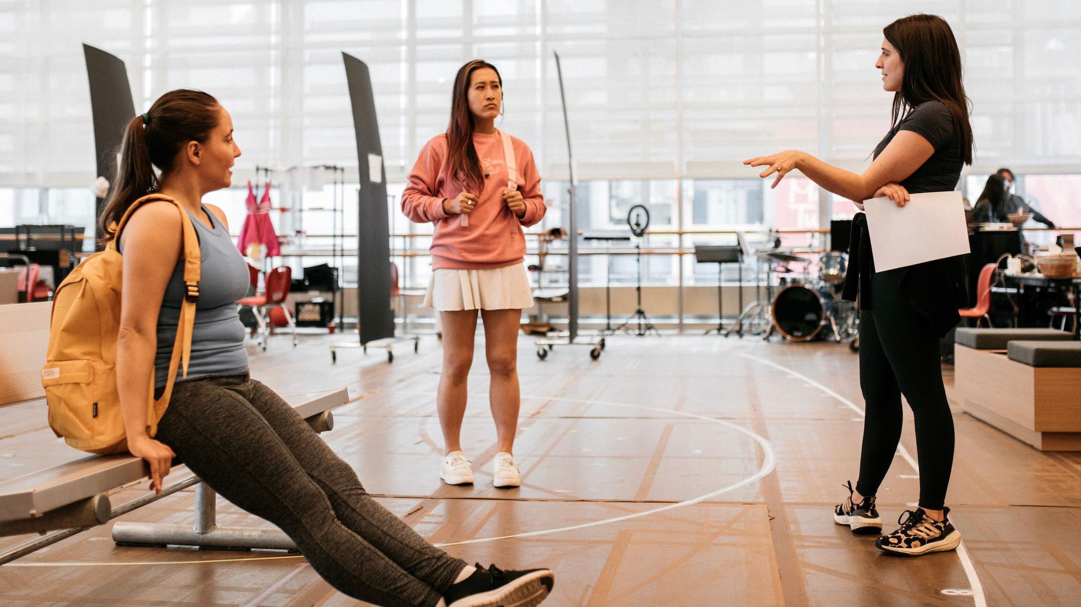 Sami stoji u prostoriji za probe i razgovara sa dve koleginice  