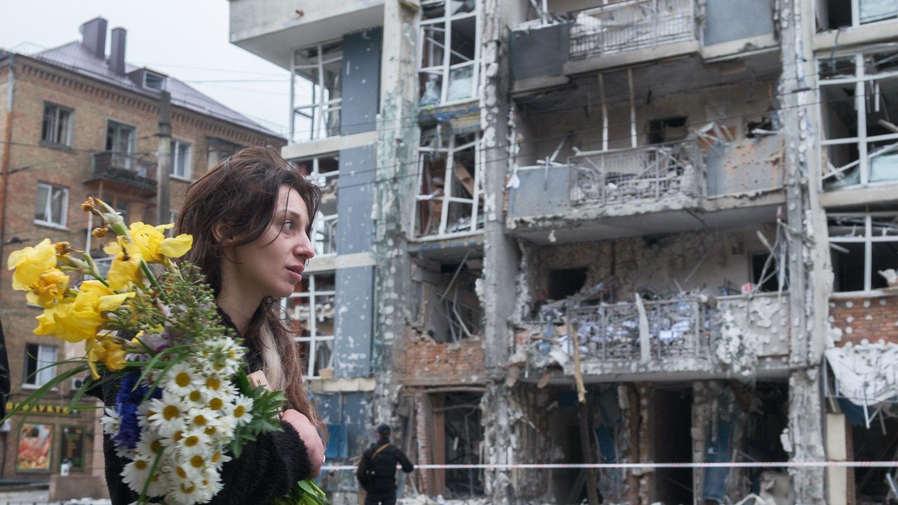 Zamrznuta ruska imovina: Šta hoće EU i zašto se Belgija protivi 1 Žena sa buketom cveća prolazi pored stambene zgrade u Ševčenkivskom okrugu Kijeva 25. maja 2025. Kosa joj je raščupana. Višespratna zgrada teško je oštećena u napadu ruskog drona