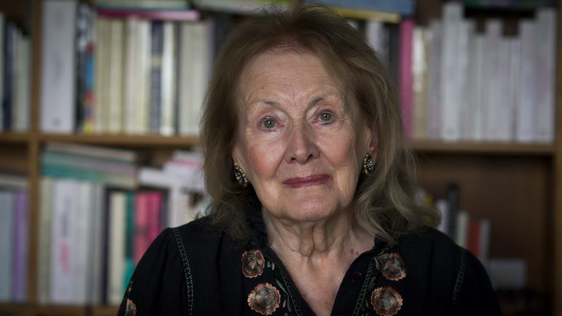 ani erno, starija žena gleda u kameru, iza nje je polica sa knjigama