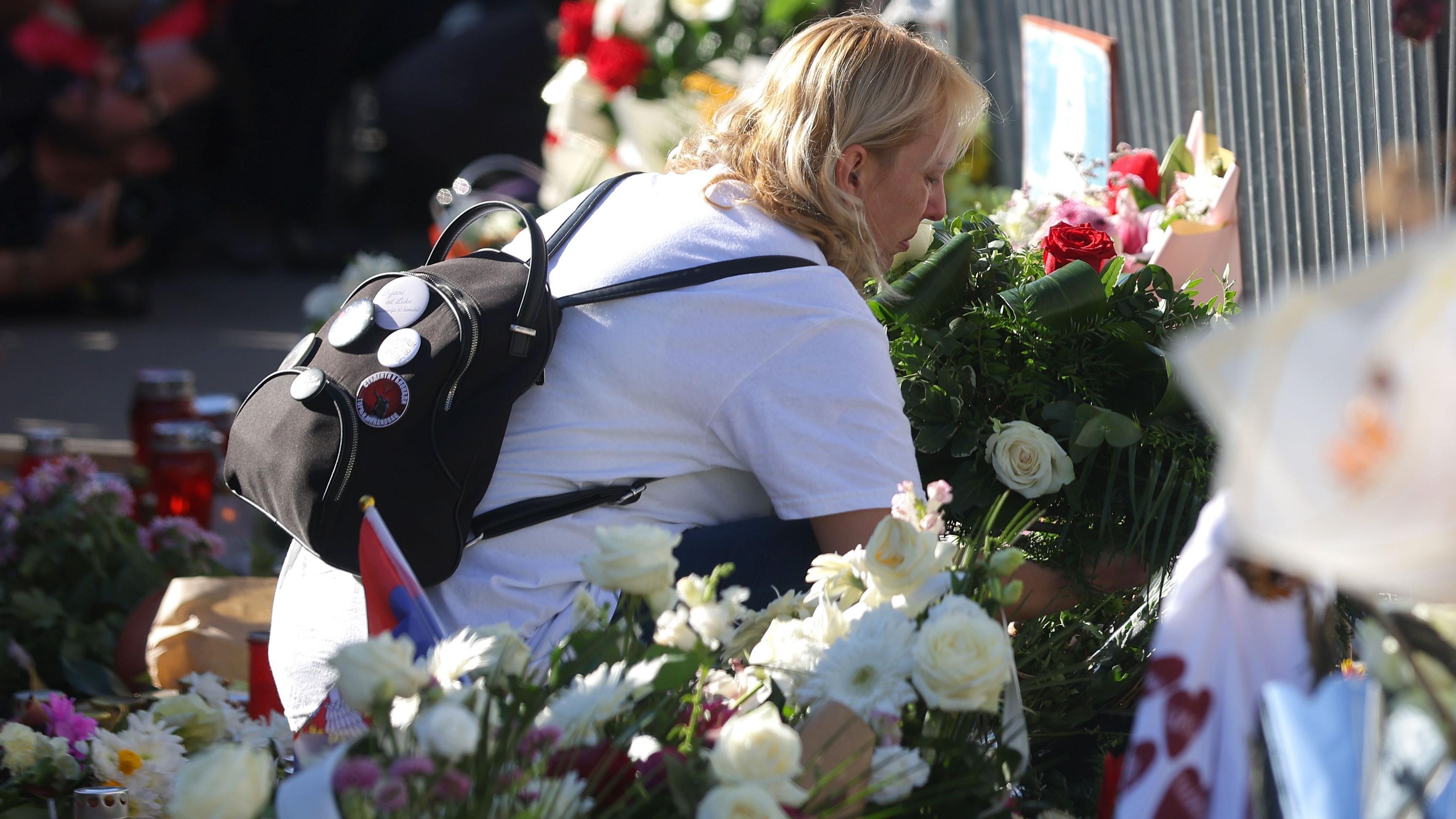 Dijana Hrka u beloj majici polaže cveće ispred Železničke stanice