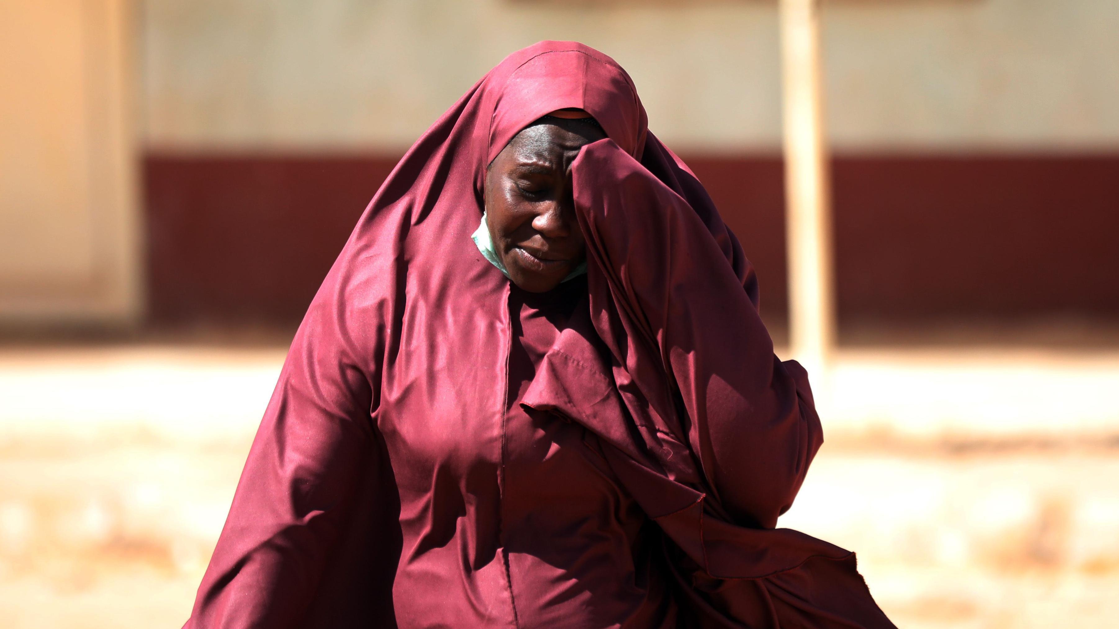 A woman whose son was abducted hold her head inside the Government Science where gunmen abducted students in Kankara, in northwestern Katsina state, Nigeria December 15, 2020
