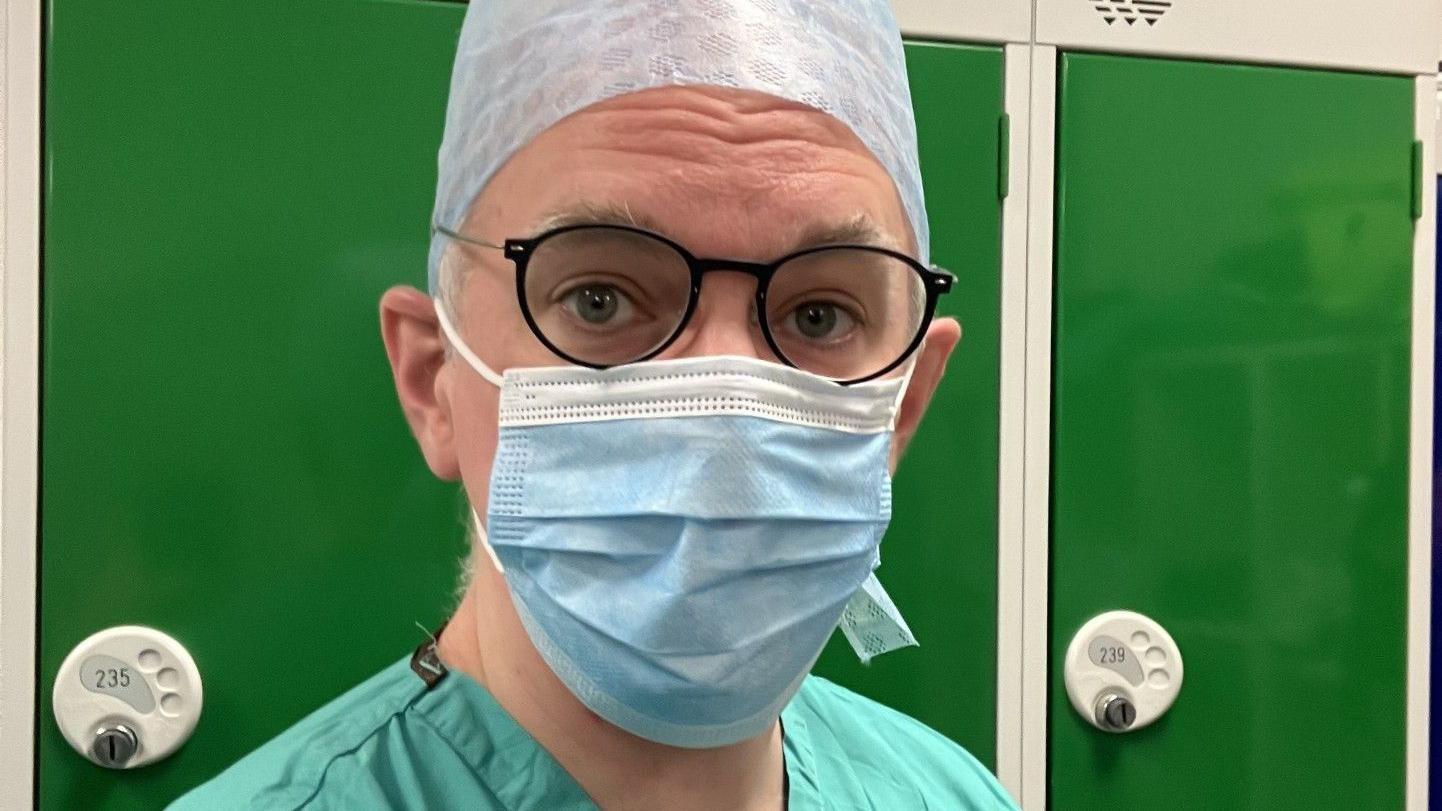 muškarac nosi hiruršku opremu, hirurg, operacija, operaciona sala