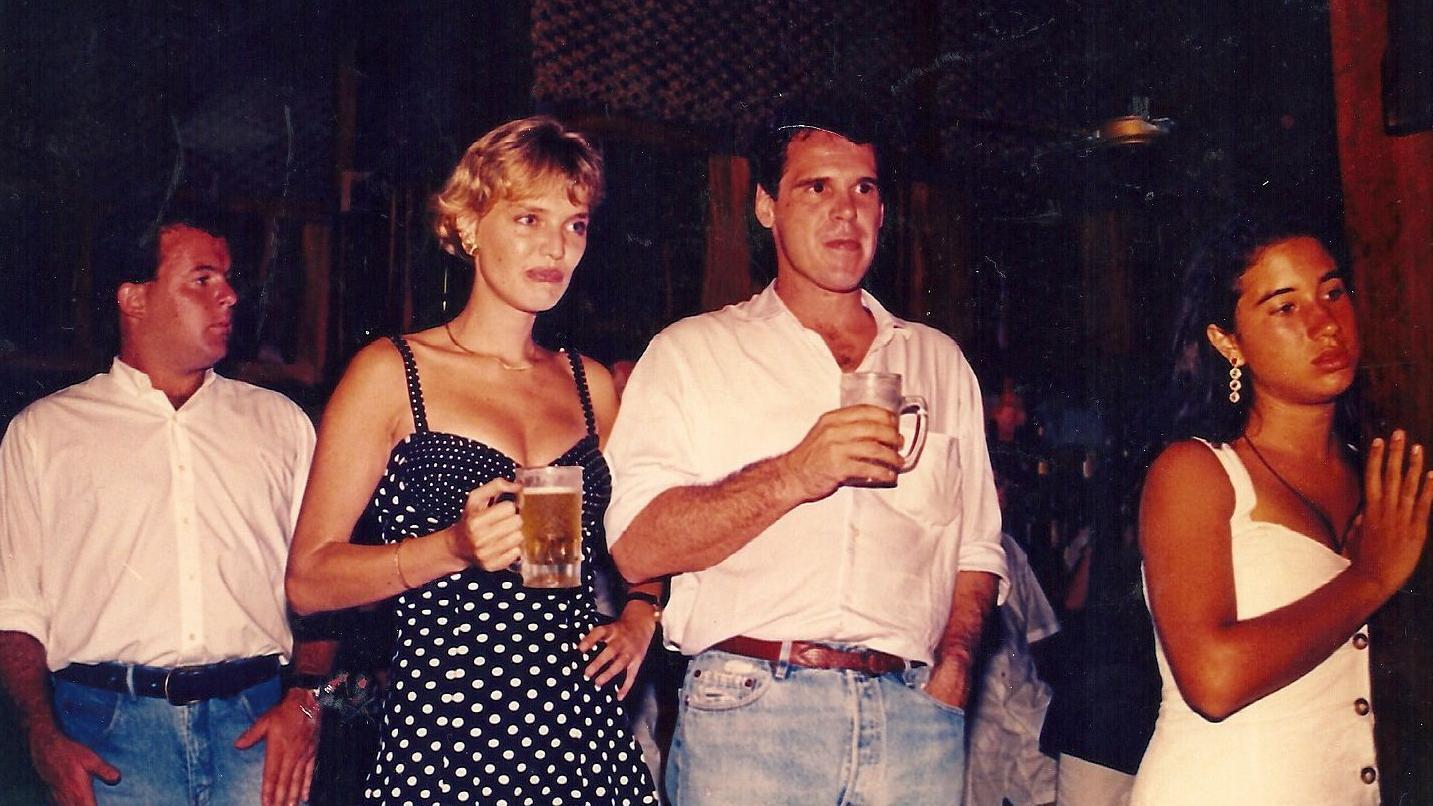 Anet i Pasje zajedno na događaju, oboje drže krigle piva u rukama, on je u beloj košulji i farmerkama desno, a ona levo u crnobeloj haljini na bretele i na tufne