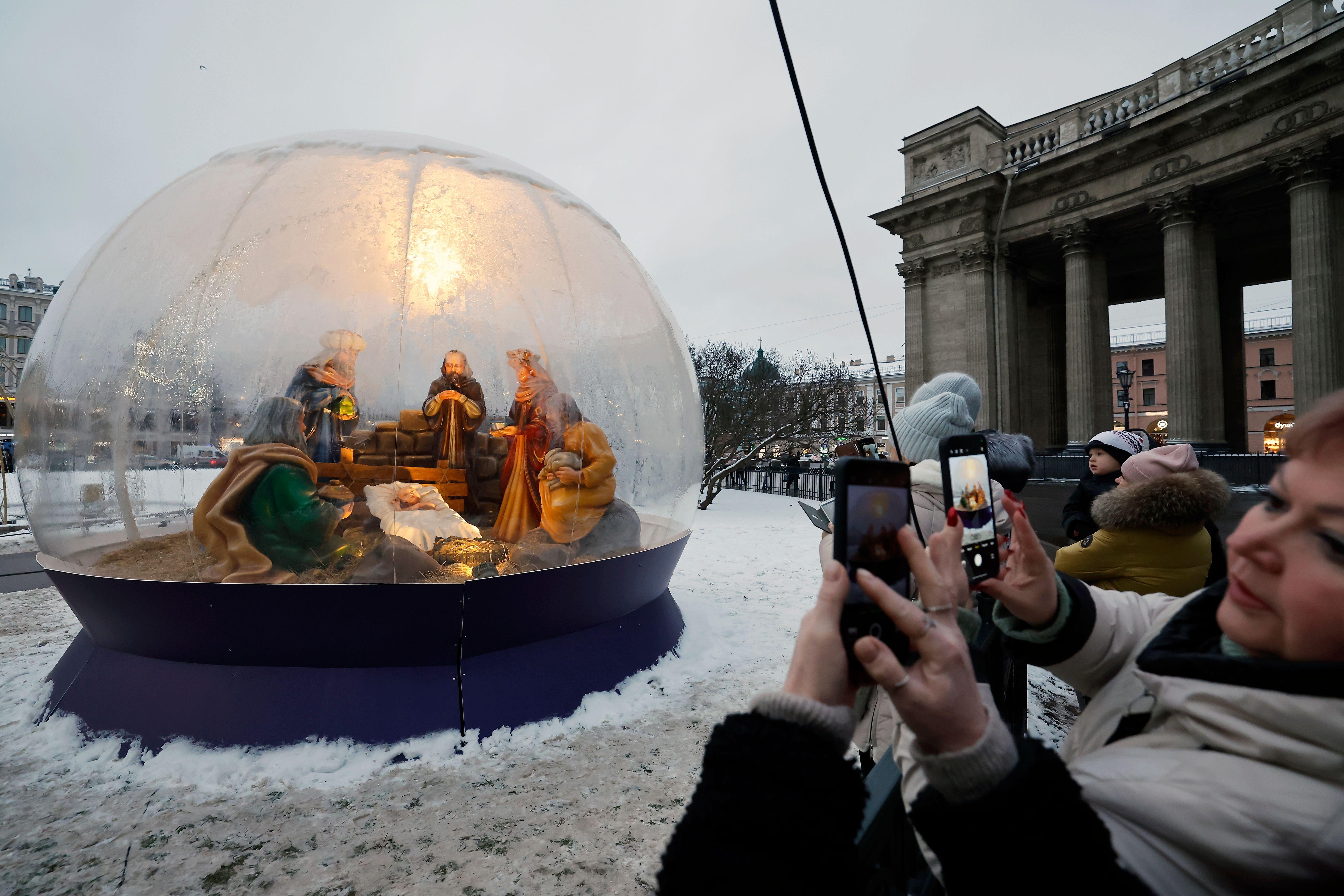 Ljudi gledaju instalaciju jaslica u blizini Kazanjske crkve uoči proslave Nove godine i Božića u Sankt Peterburgu, Rusija, 24. decembra 2025. Rusi se spremaju da proslave Novu godinu 31. decembra i Božić, koji se obeležava 7. januara, ruskom pravoslavnom julijanskom kalendaru.