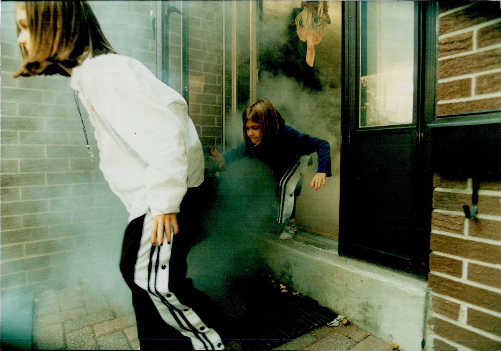 Dve devojčice iskaču iz zadimljene zgrade tokom vežbe evakuacije