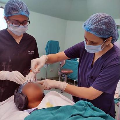 Dve medicinske sestre i jedna pacijentkinja na stolu sa slušalicama na ušima