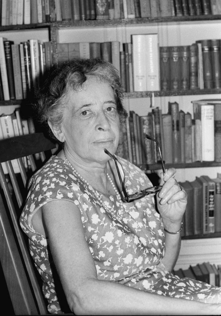 Crno-bela fotografija starije žene koja u jednoj ruci drži naočare za vid 