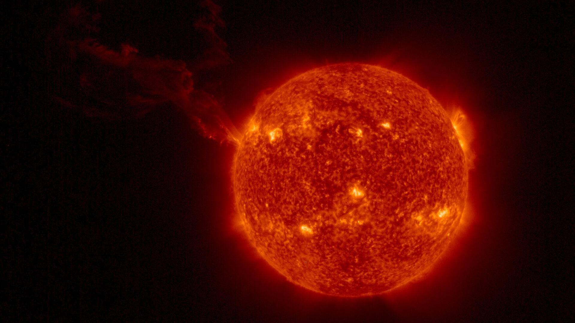 Astronomi uočili do sada neviđeni bljesak iz supermasivne crne rupe 3 Sunce se vidi kao crvena lopta sa žutim tačkama na površini; dugačak oblak se proteže ulevo.