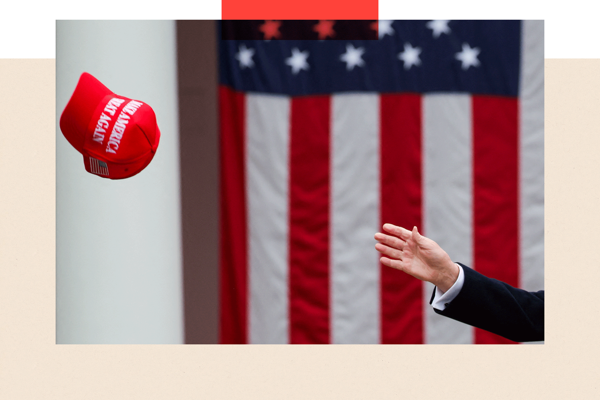 Ruka koja pokušava da uhvati kačket MAGA iza njih je američka zastava
