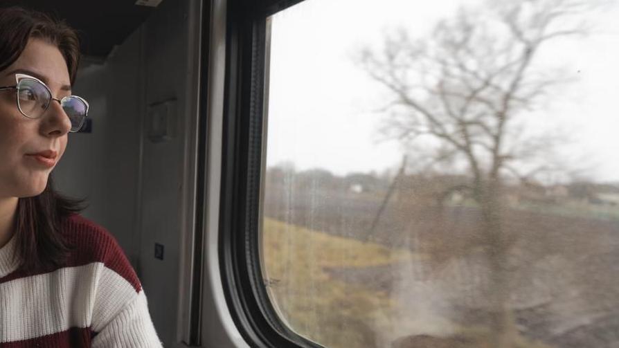 Devojka sa naočarima putuje vozom