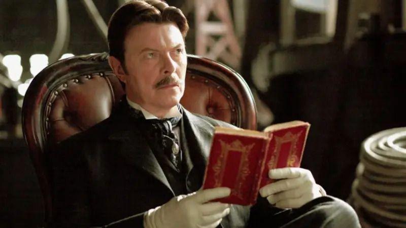 Kako se Balkan seća Dejvida Bouvija, maštovitog rokenrol buntovnika 5 Dejvid Bouvi sa brkovima u odelu drži crvenu knjigu