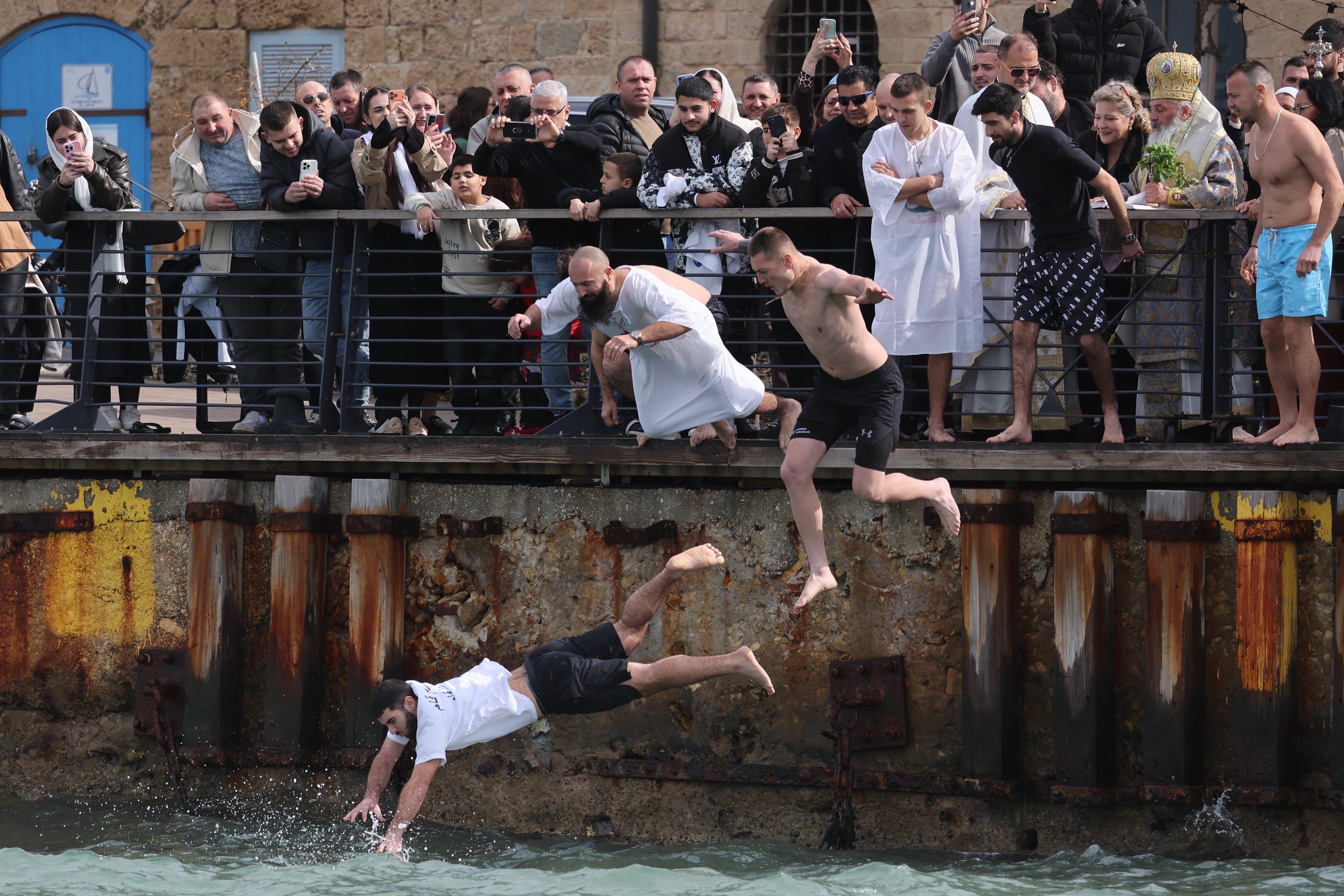 Hrišćanski vernici iz grčke pravoslavne crkve Arhangela Mihaila skaču u vodu kako bi izvukli krst iz Sredozemnog mora tokom proslave Bogojavljanja u Staroj luci Jafa u Tel Avivu, Izrael, 19. januara 2026.