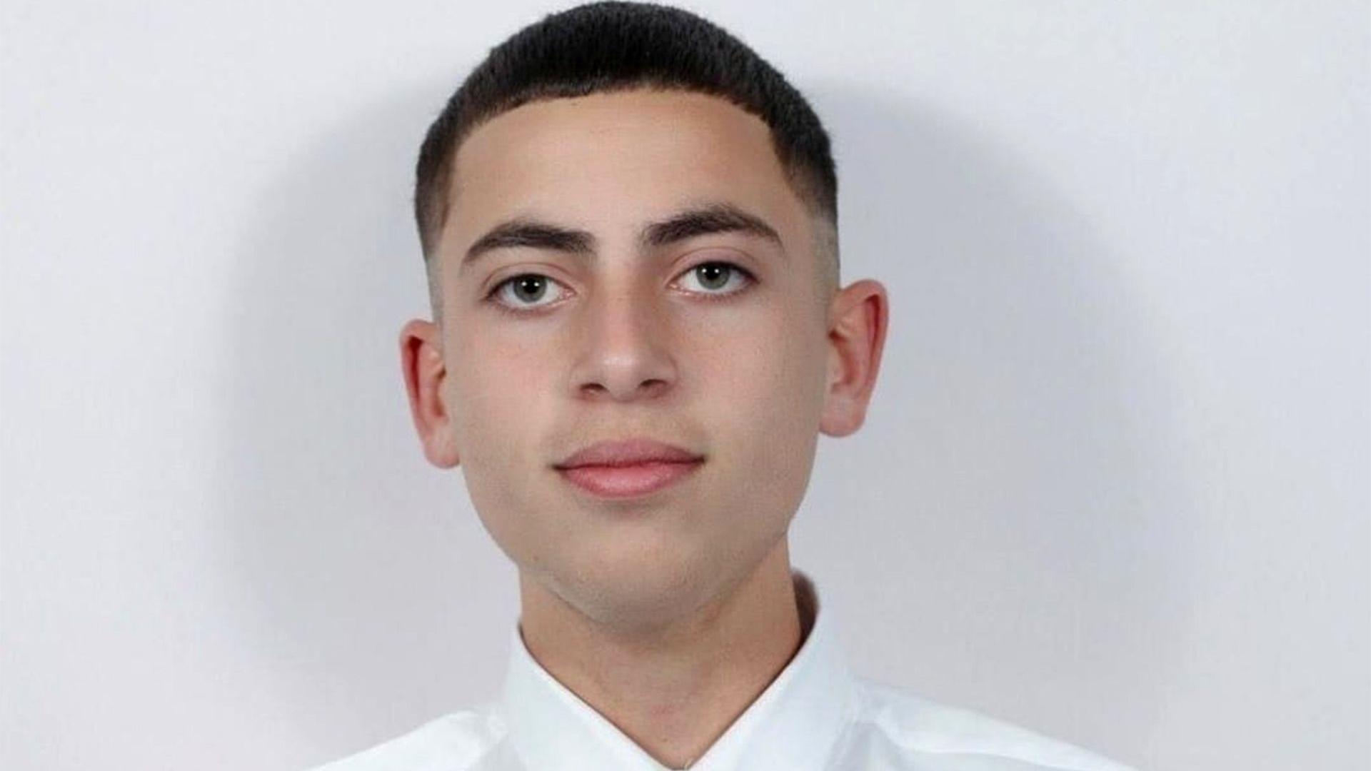 Tinejdžer sa kratkom tamnom kosom u beloj košulji. Gleda u kameru i blago se osmehuje. 