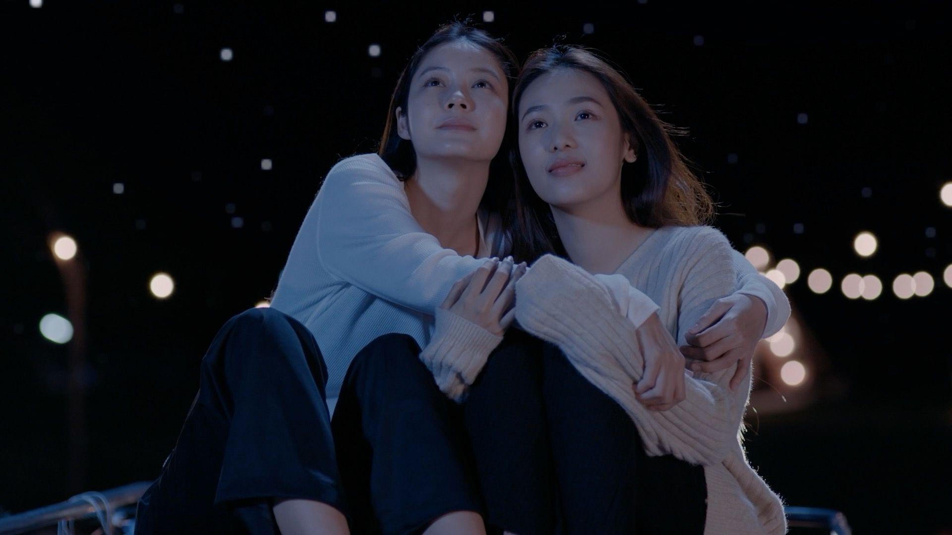 Kako su tajlandske lezbejske ljubavne priče postale višemilionska industrija 8 Dve devojke u belim džemperima se grle gledajući ka nebu