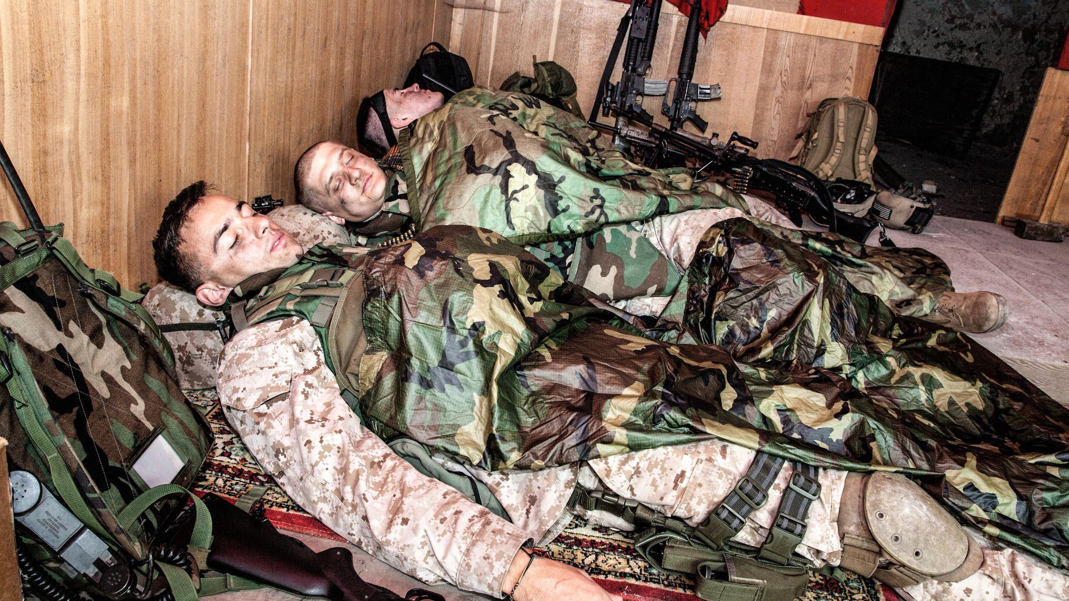 Trojica vojnika, obučeni u kamuflažne unirome i sa pancirima, spavaju u uglu sobe. Naslonjeni su na rančeve, a oružje im je nadohvat ruke, kao da će svakog trenutka biti spremni da se vrate na prvu liniju fronta.