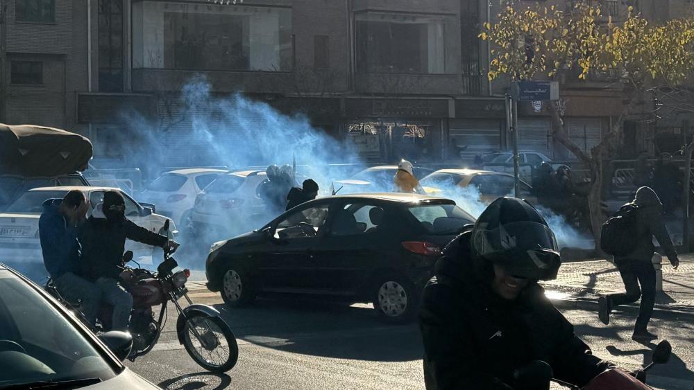 Suzavac koji se širi ulicom na kojoj su ljudi na motorima okruženi automobilima