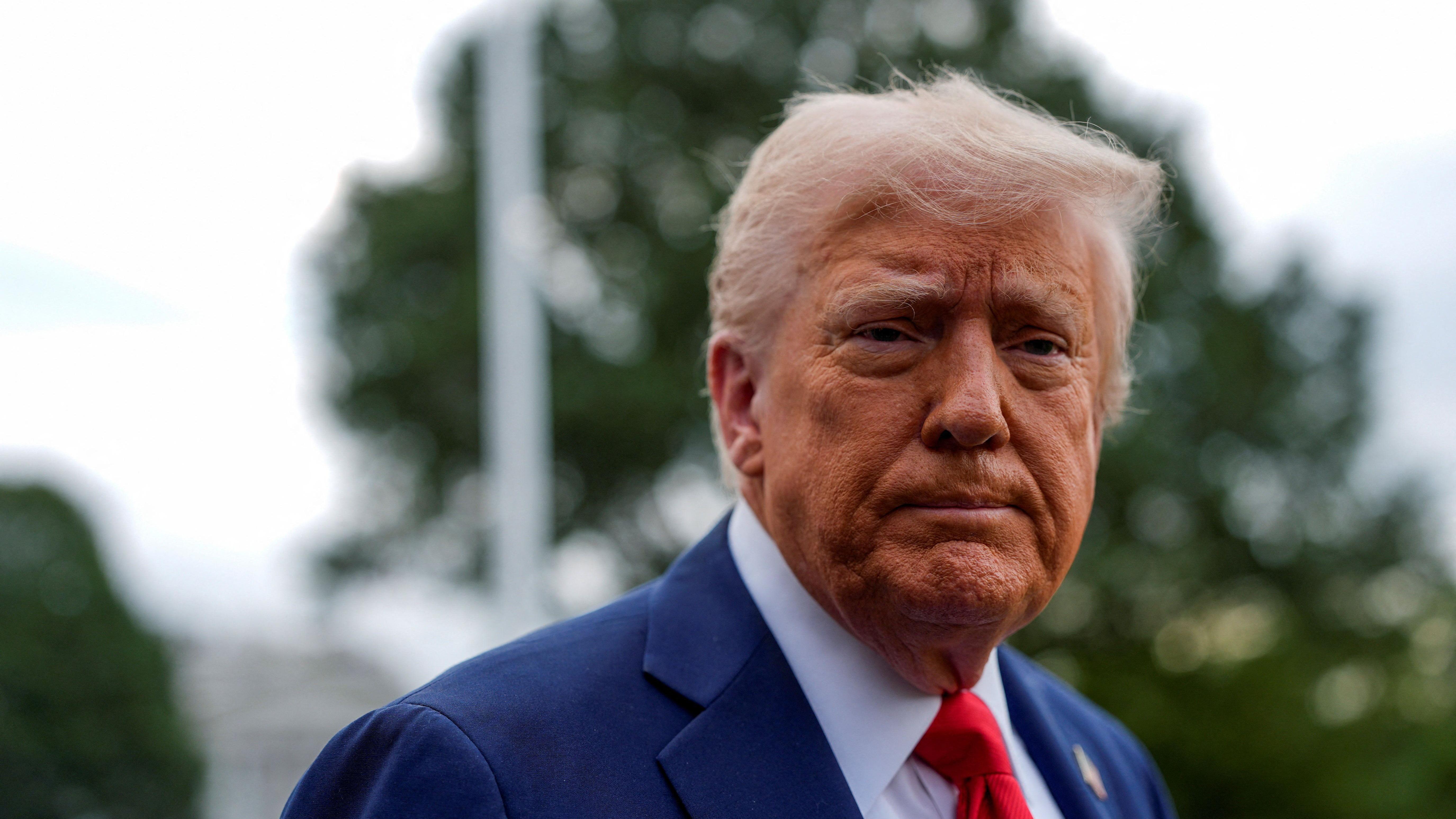 Američki predsednik Donald Tramp u plavom odelu, beloj košulji i crvenoj kravati gleda u kameru