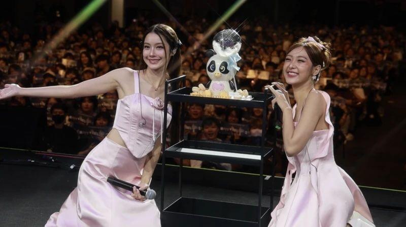 Kako su tajlandske lezbejske ljubavne priče postale višemilionska industrija 3 Dve devojke u rozim haljinama na sceni okrenute publici leđima