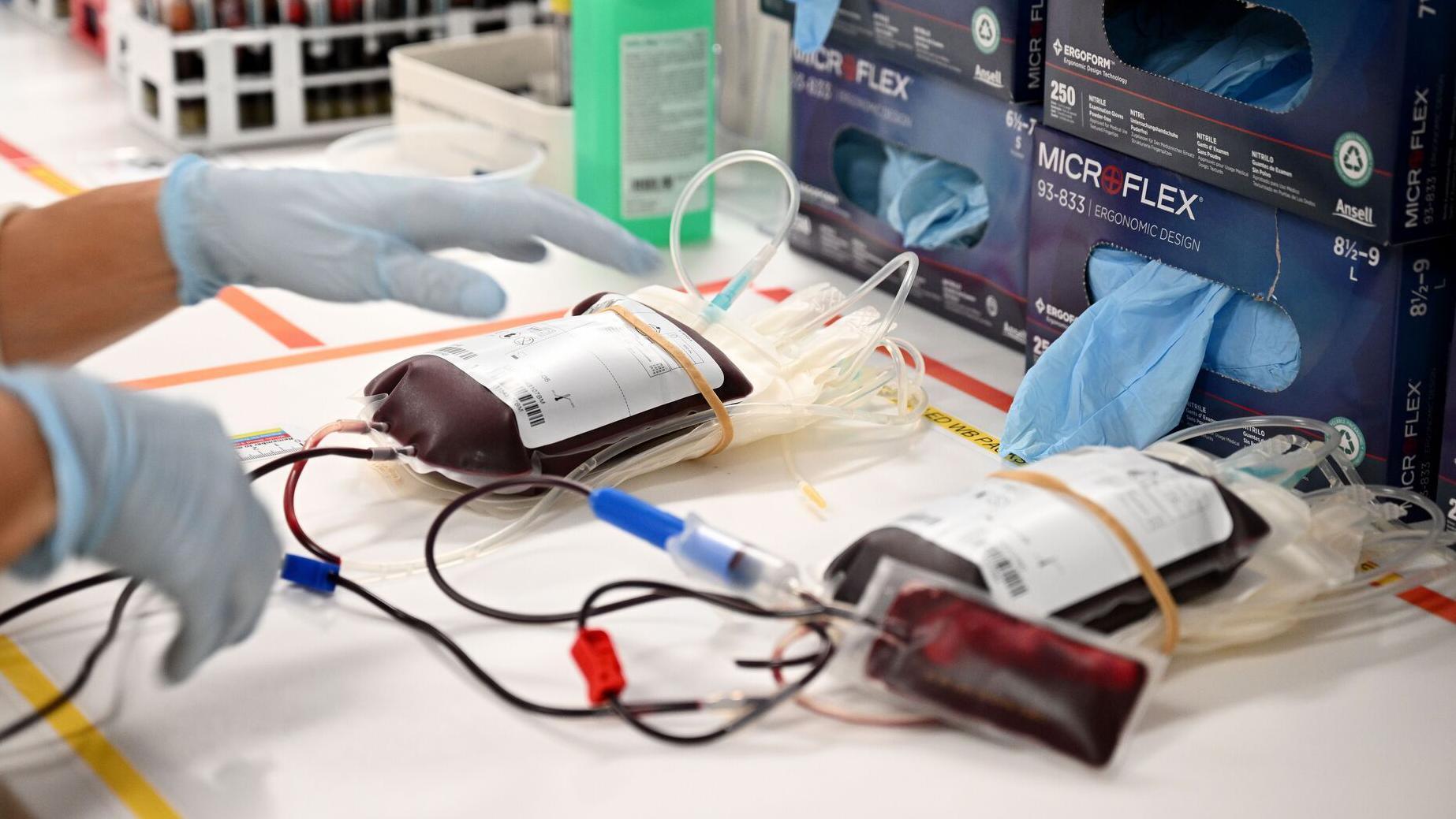 Dve jedinice krvi, medicinski špricevi i ruke medicinskog radnika