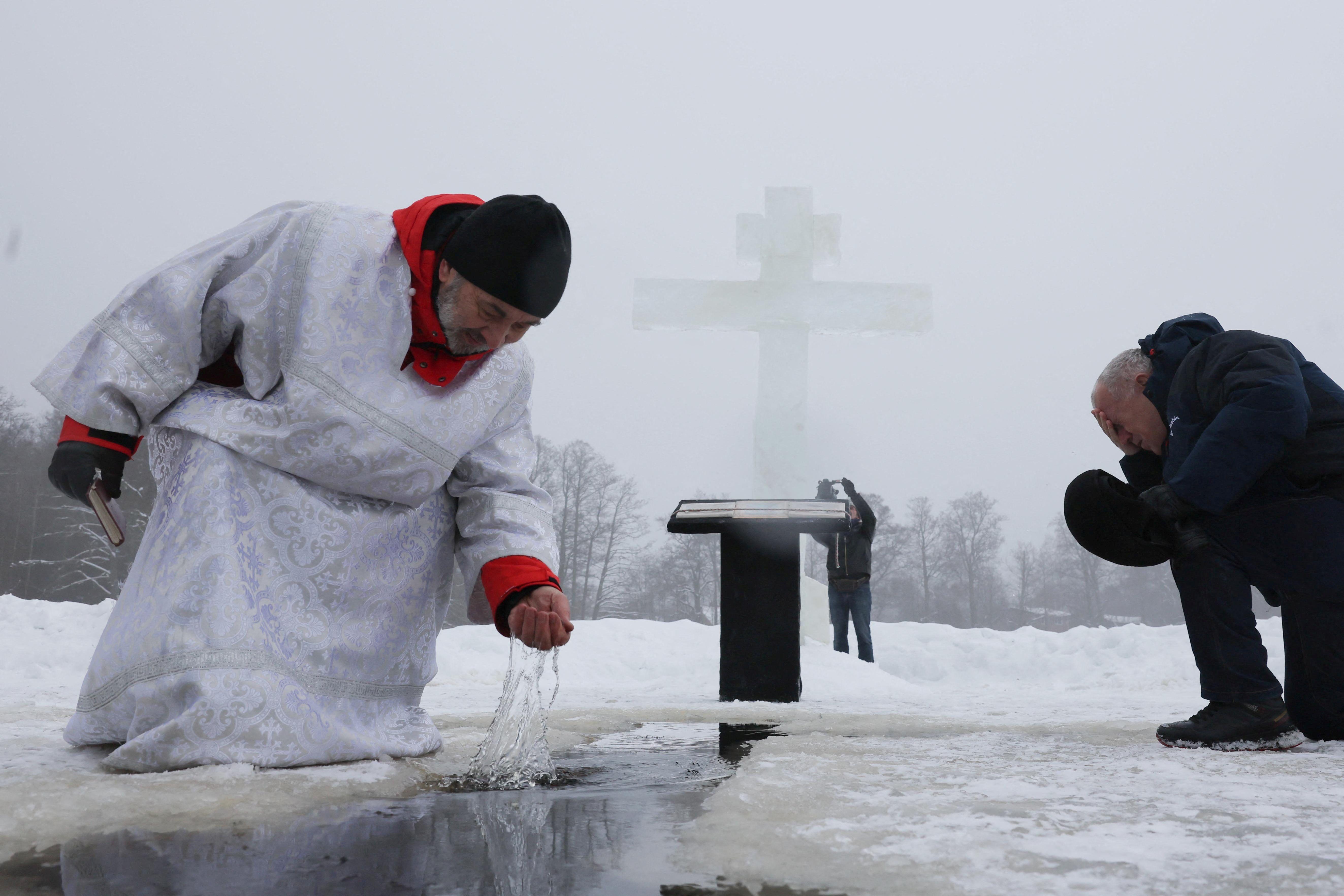 Sveštenik zahvata vodu tokom proslave pravoslavnog hrišćanskog praznika Bogojavljanja u blizini sela Gora-Valdaj, izvan Sankt Peterburga u Lenjingradskoj oblasti, Rusija, januar 2026.