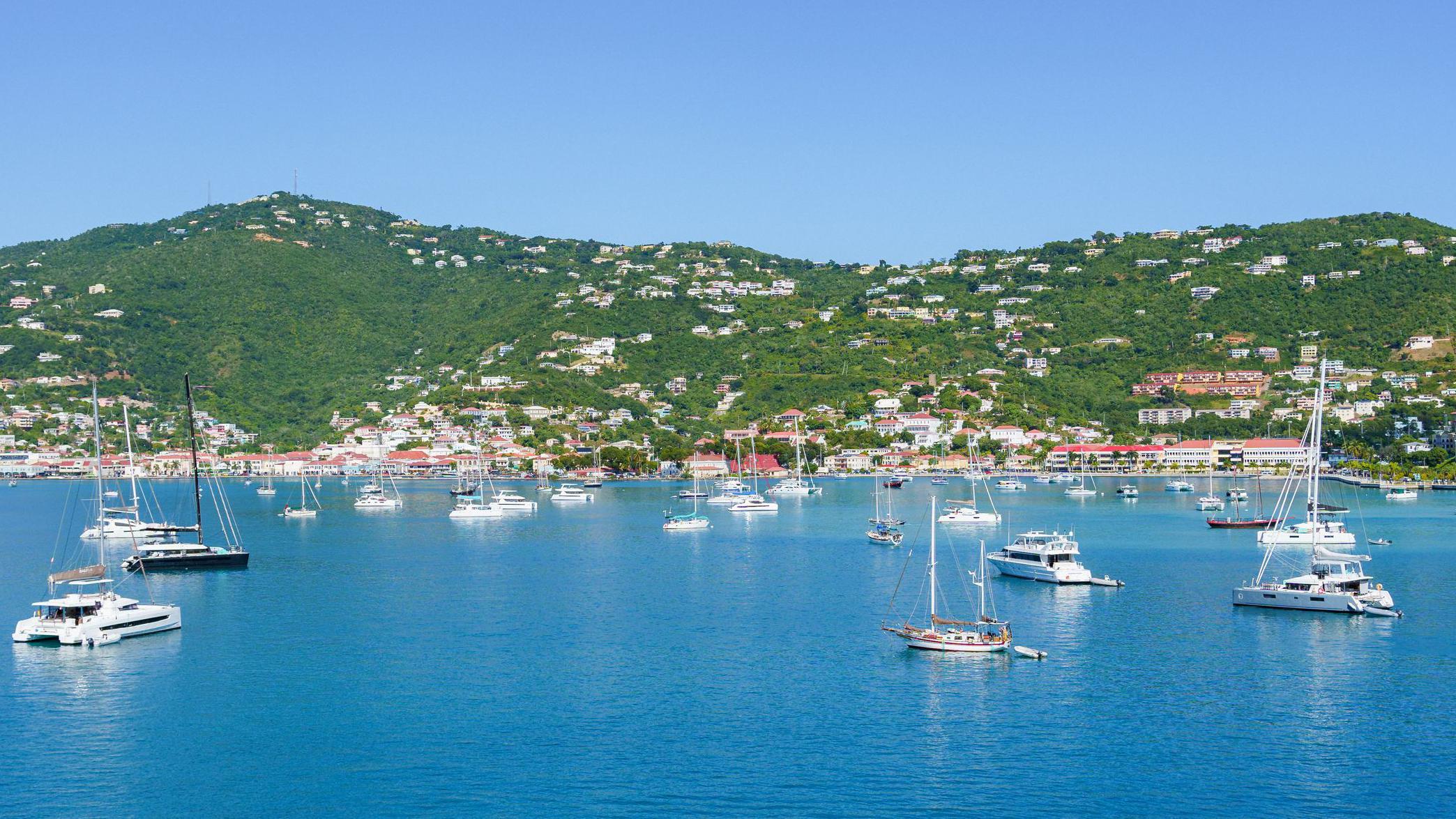 Kako je Danska prodala Devičanska Ostrva Americi i ima li to veze sa Grenlandom 1 Beli čamci usidreni u zalivu plave vode, ispred zelenih, drvećem obraslih brda isprekidanih belim zgradama, na ostrvu Sent Tomas na Američkim Devičanskim Ostrvima.