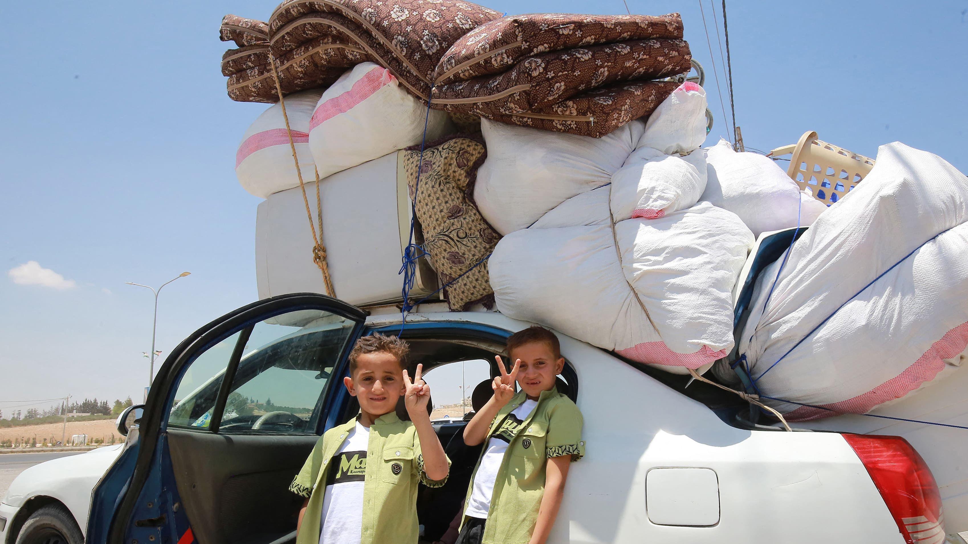Kako odrastanje u ratu zaista utiče na jednog 11-godišnjaka 10 Dva dečaka gestikuliraju dok sirijska izbeglička porodica ulazi u automobil natovaren stvarima
