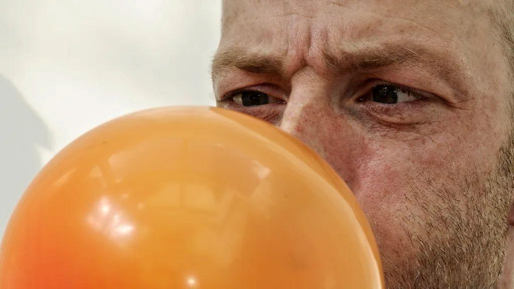 muškarac duva balon