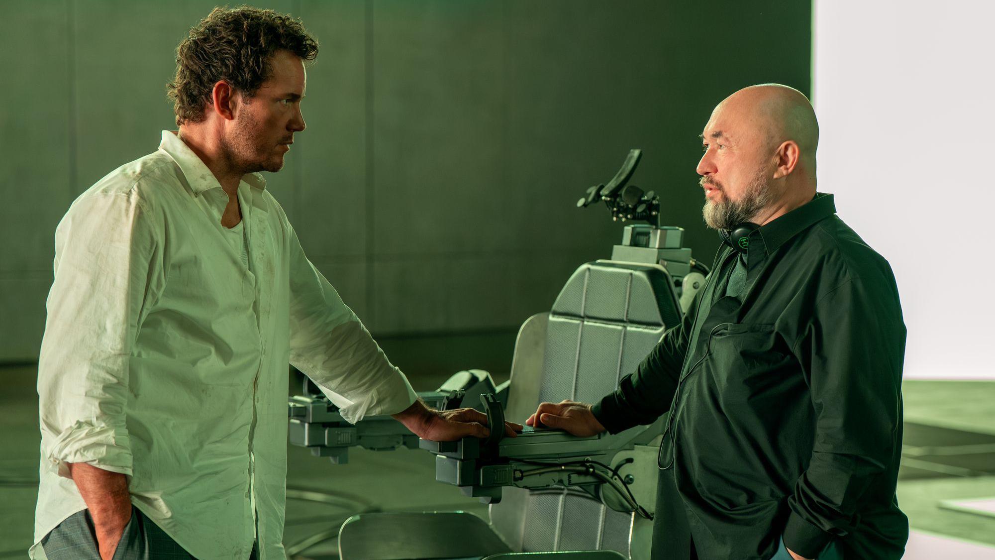 Kris Prat i reditelj Timur Bekmambetov stoje jedan naspram drugog i razgovaraju, oslanjajući se rukama na stolicu za pogubljenje