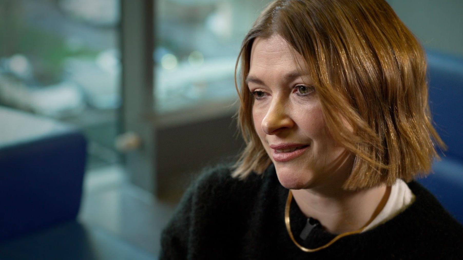 žena sa kratkom kosom gleda u kameru