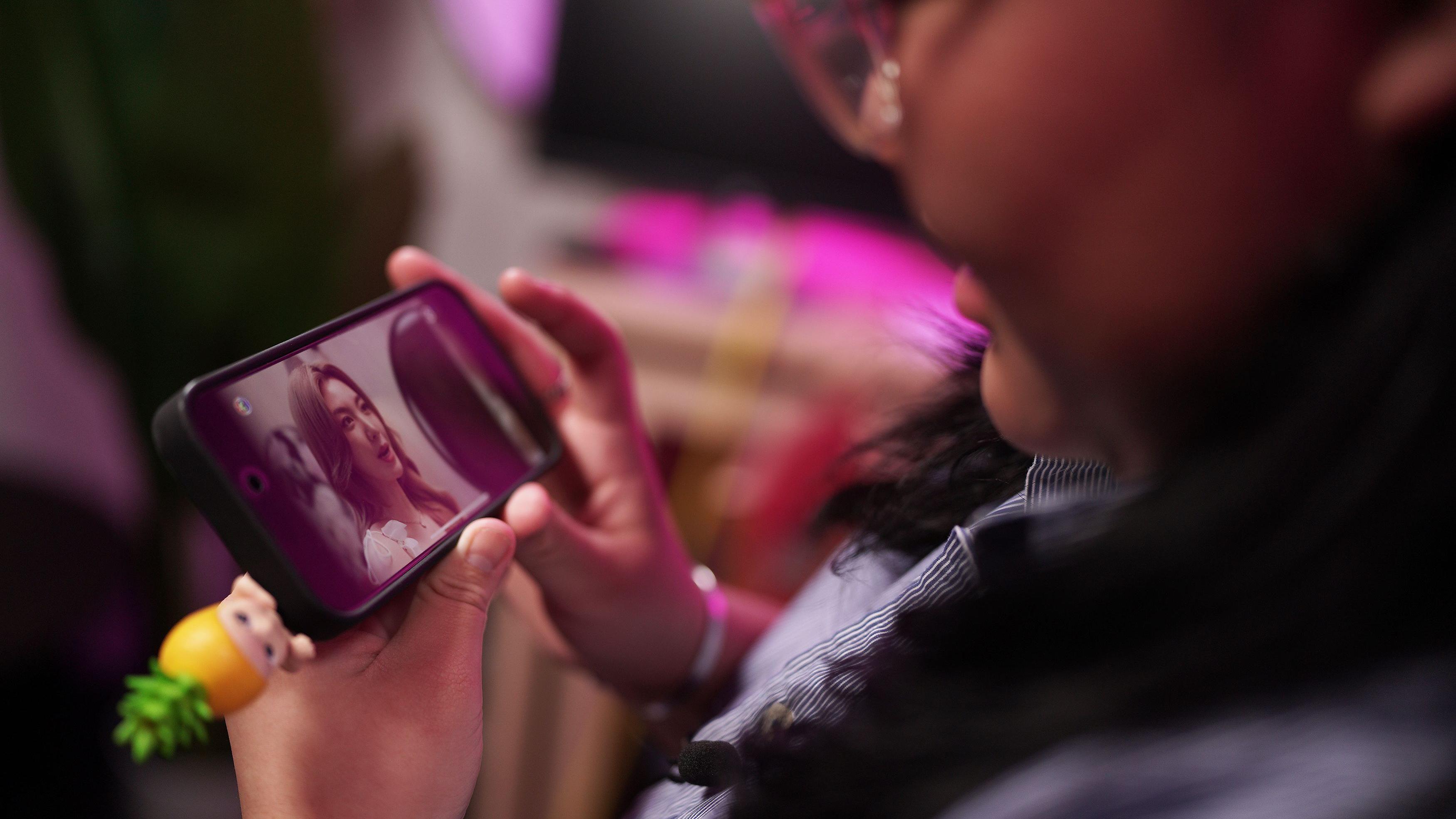 Kako su tajlandske lezbejske ljubavne priče postale višemilionska industrija 5 Devojka oduševljeno gleda u ekran telefon