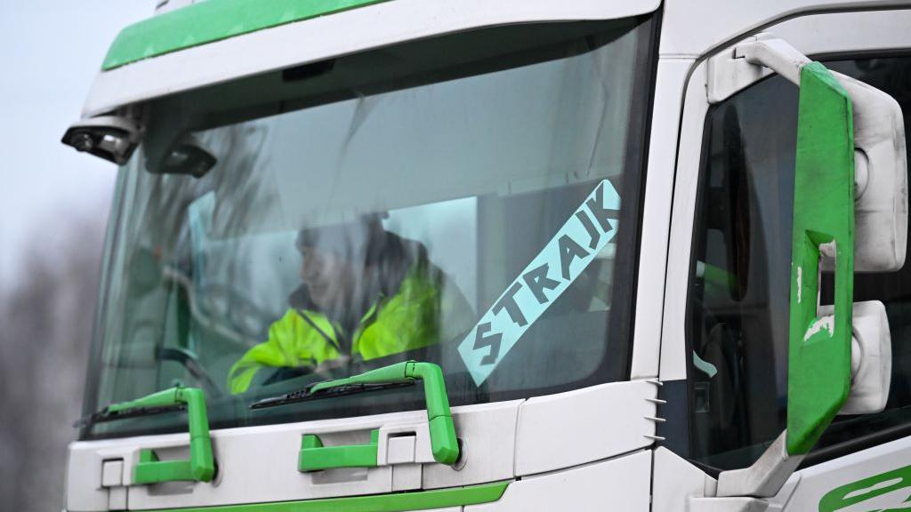 vozač sedi u kamionu na kome piše štrajk