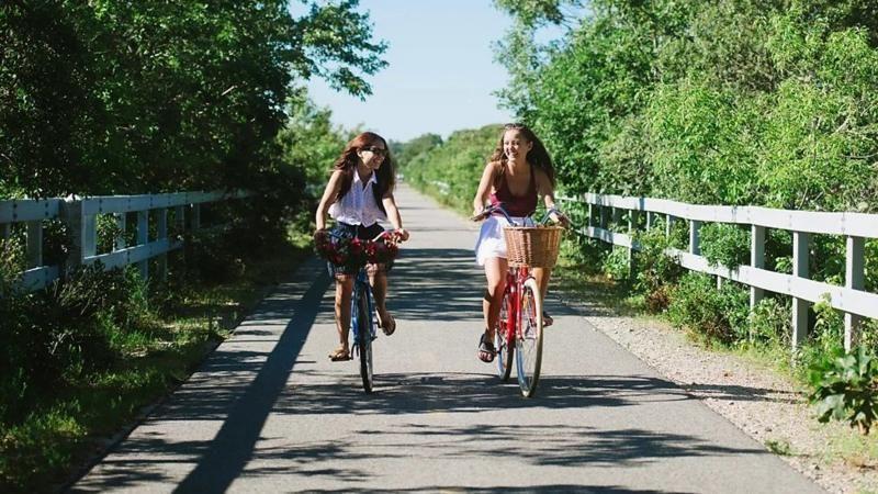 Devojčice voze bicikl okružene drvećem