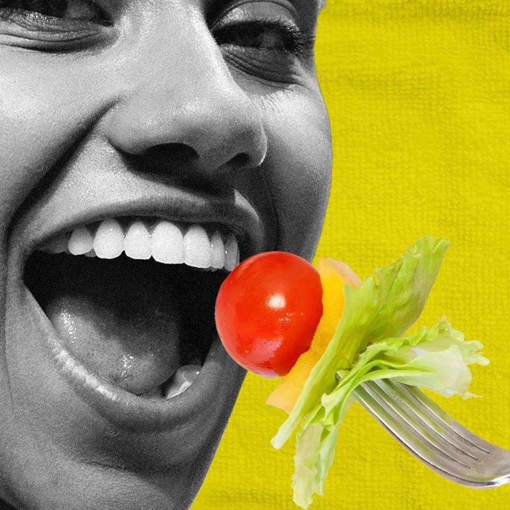 Šta treba jesti u različitim periodima života 4 Žena gleda u kameru dok ustima prinosi viljušku sa paradajzom, paprikom i zelenom salatom