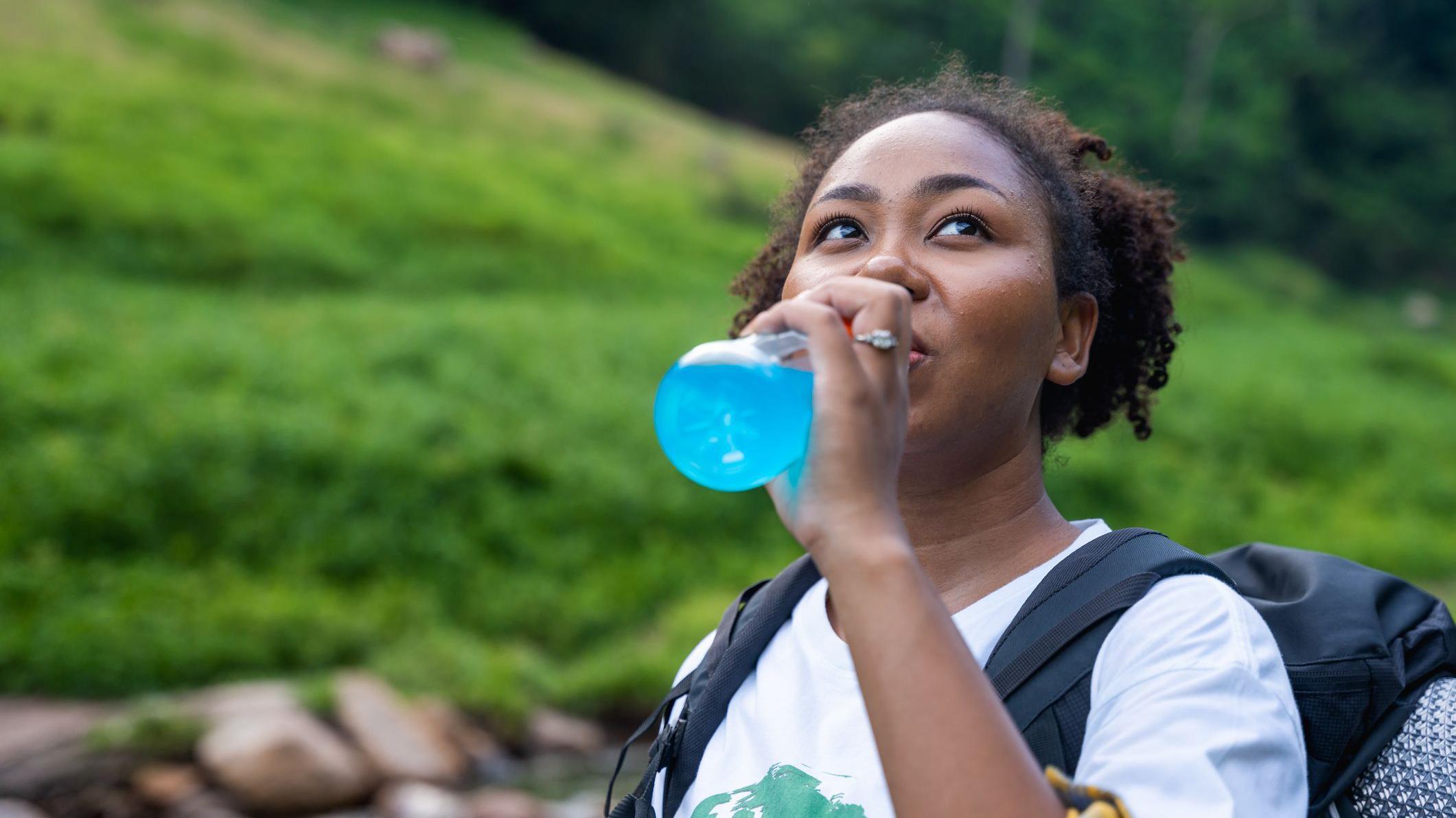 Jesu li elektroliti zaista neophodni tokom vežbanja 1 Devojka pije elektrolitski napitak u prirodi