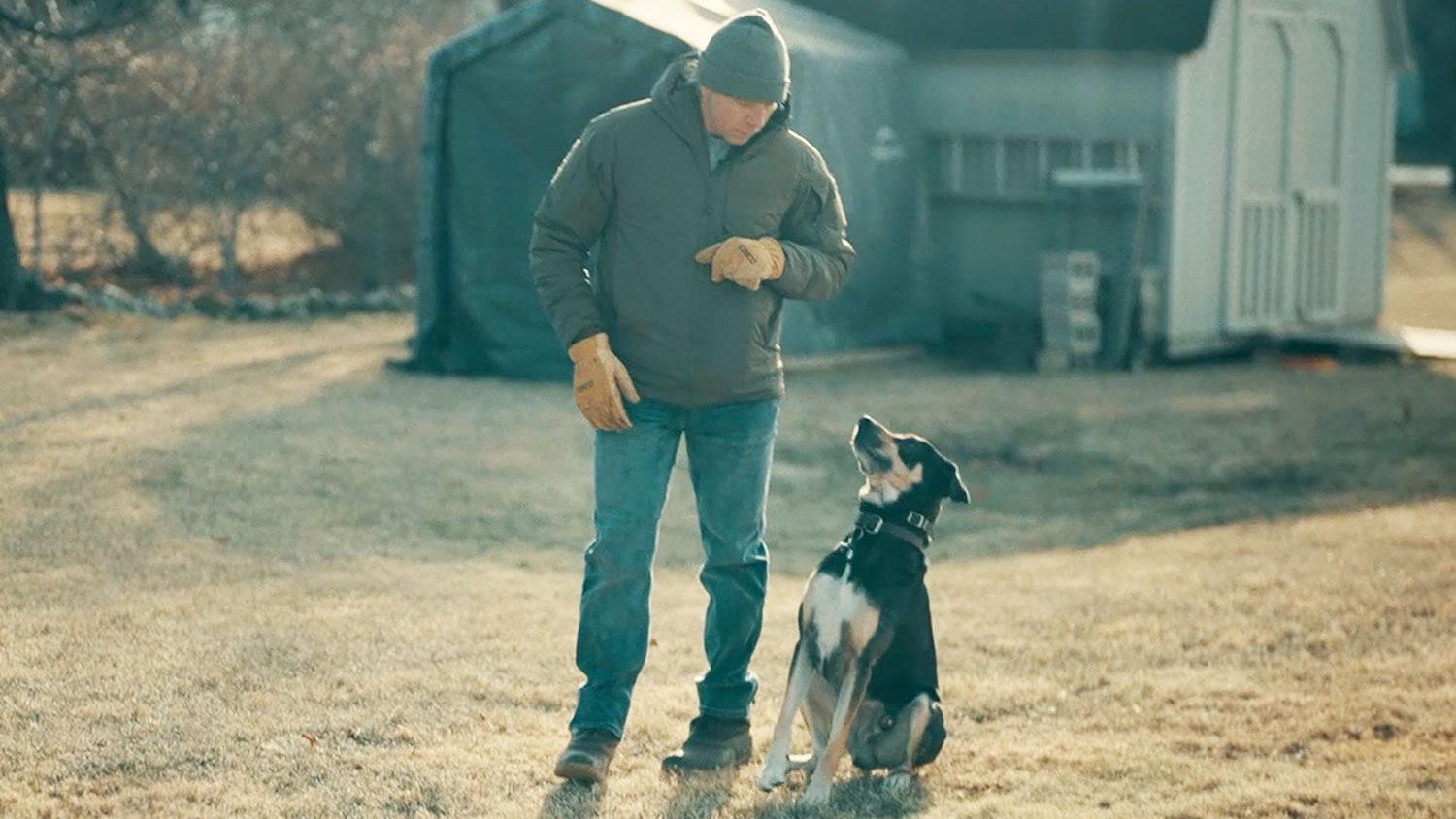 Obična cigla pomogla da se pronađe godinama zlostavljana devojčica 4 muškarac sa psom u šetnji blizu kuće - gleda odozgo u crno-belog i žutosmeđeg psa koji ga gleda