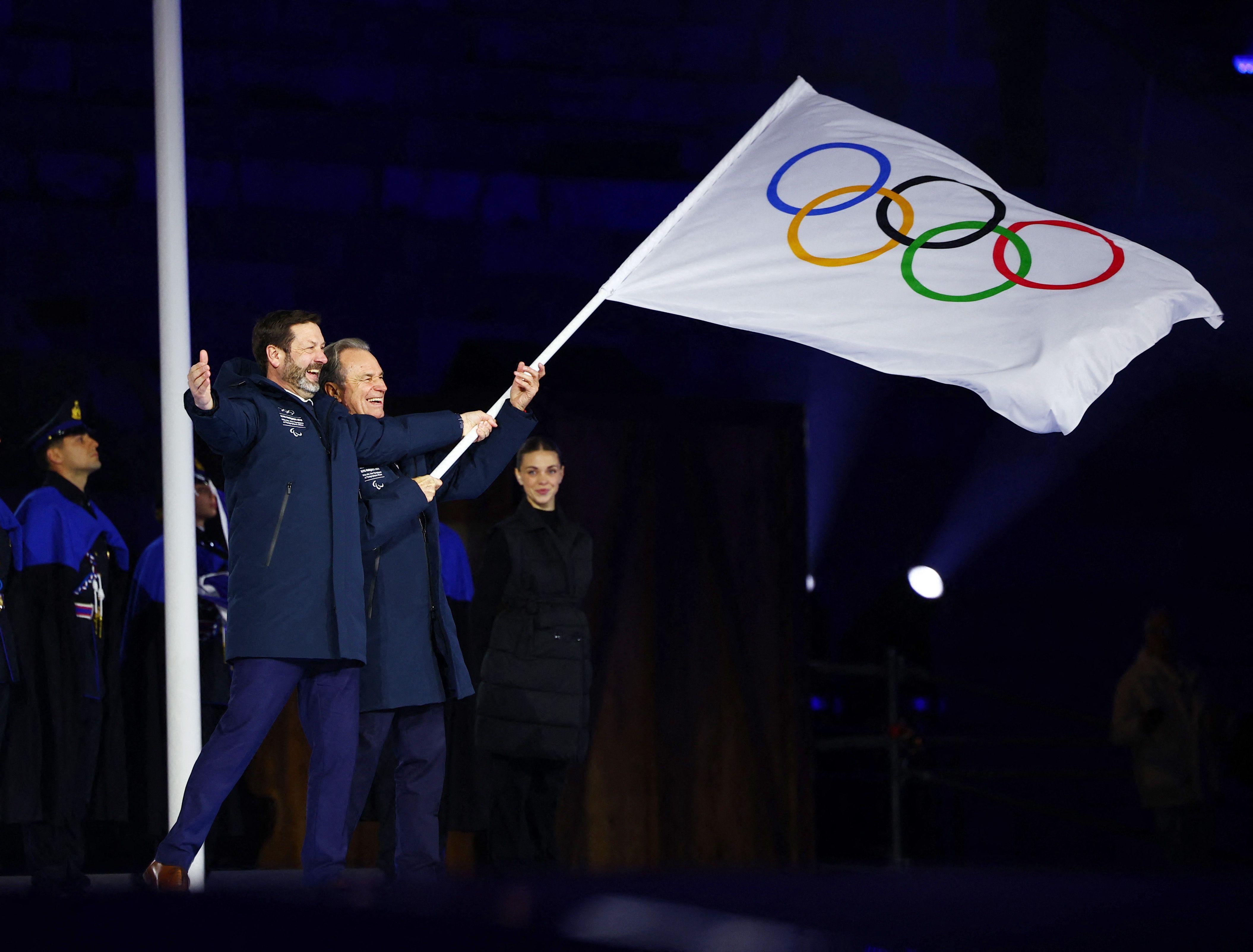 Zatvaranje Zimskih olimpijskih igara kroz fotografije 13 Predsednici francuskih regiona Reno Muzelije i Fabris Panekuk mašu olimpijskom zastavom tokom ceremonije predaje zastave
